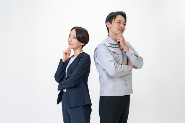 alt="ローコスト住宅の他社比較をイメージした写真。スーツ姿の女性と作業服姿の男性が背中合わせで考えるポーズをとっている。ハウスメーカーの選択や違いを検討している様子を表現。"
